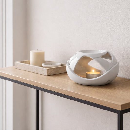 The Axis ceramic wax burne in white shown on a console table in a hallway