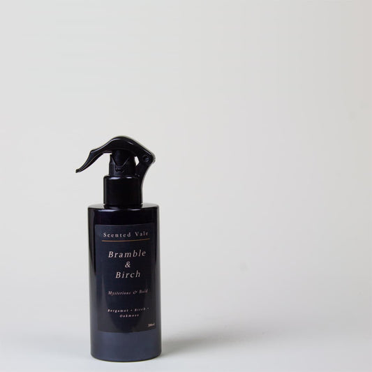 A violet spray bottle labelled 'Scented Vale Bramble & Birch' stands on a neutral grey background