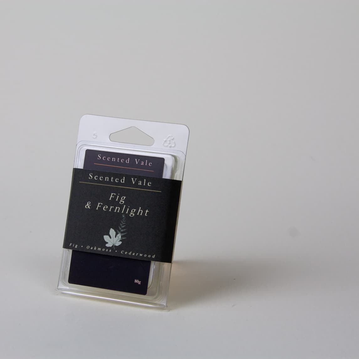 Scented Vale Fig & Fernlight wax melt package in a clear plastic clamshell and deep green label, photographed on a light grey background.