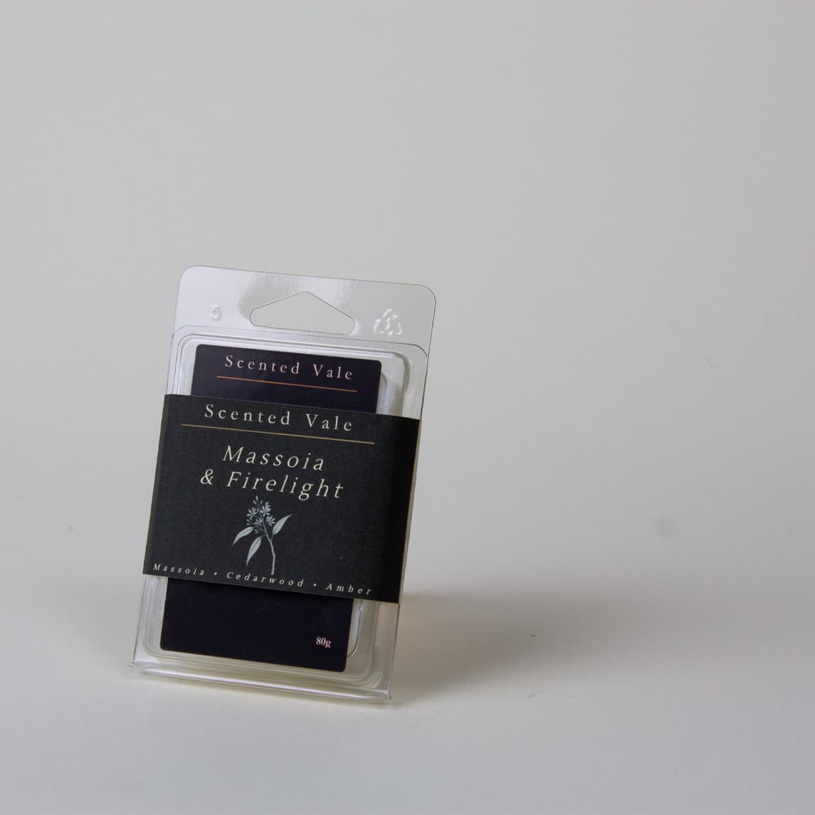 Scented Vale 'Massoia & Firelight' wax melts in a clear plastic clamshell package with a Dark label, photographed on a plain light grey background.