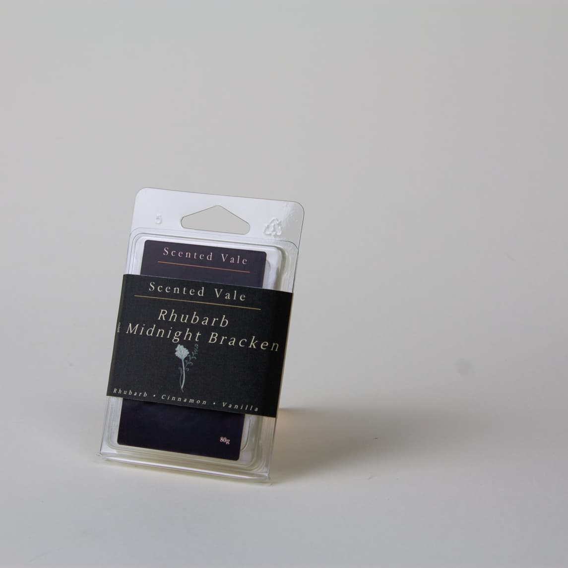 Scented Vale Rhubarb Midnight Bracken wax melts in a clear plastic clamshell package with a dark paper band label, photographed on a plain light grey background.