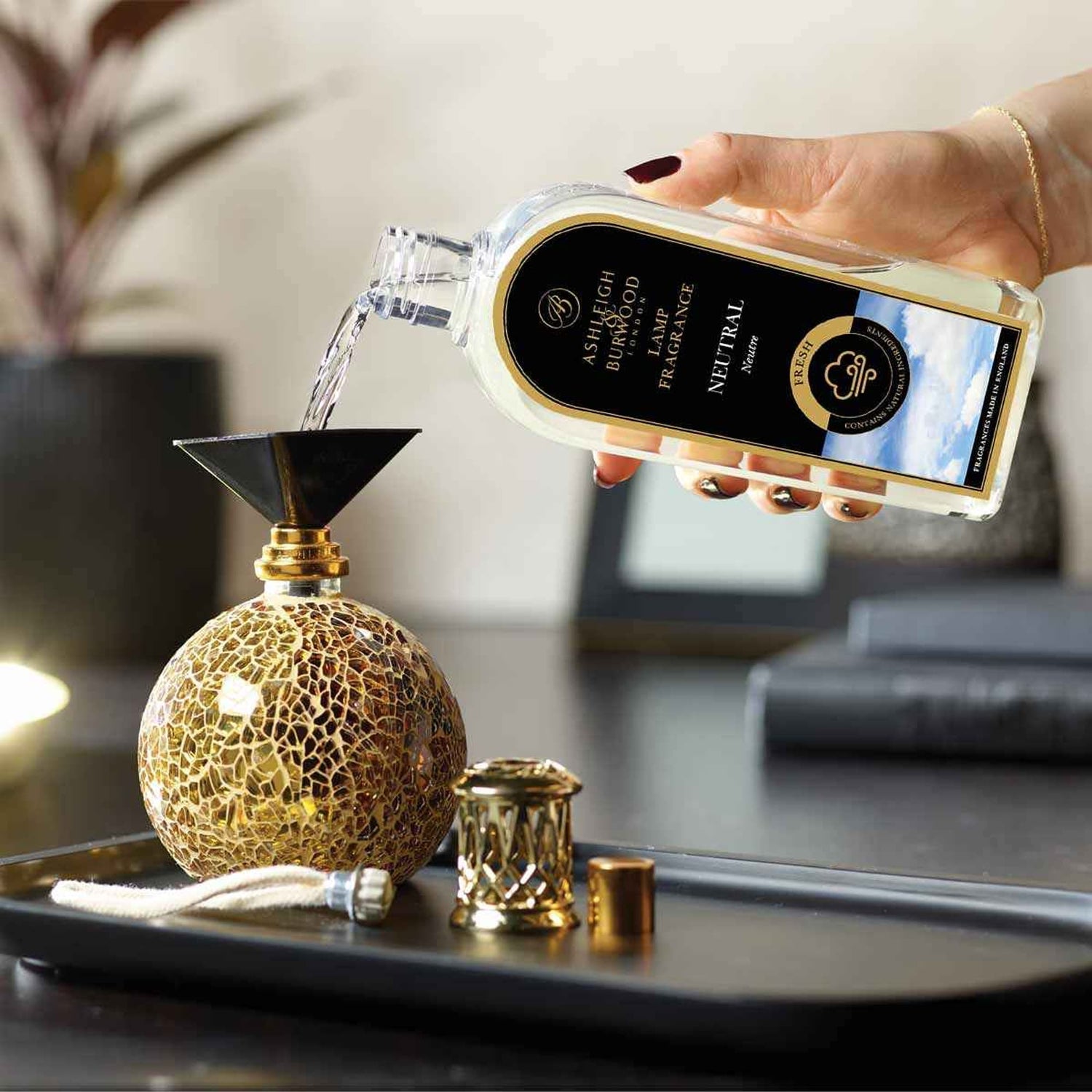 Fragrance lamp accessories shown being used with oil being poured into the funnel and replacement wick