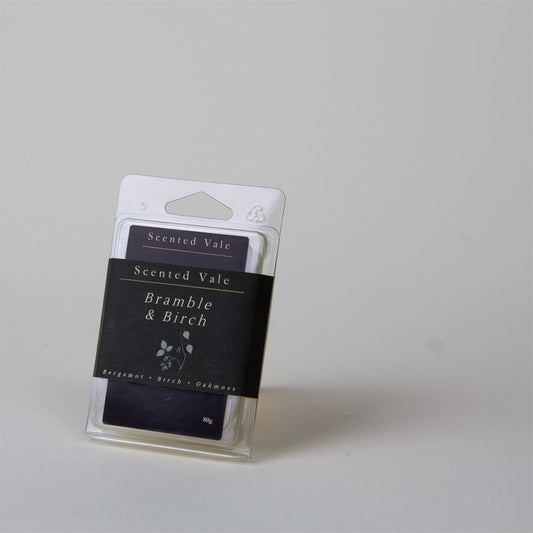 A packaged scented wax melt labelled 'Scented Vale Bramble & Birch' in a clear plastic sleeve with a dark paper band  and, photographed on a plain light grey background.