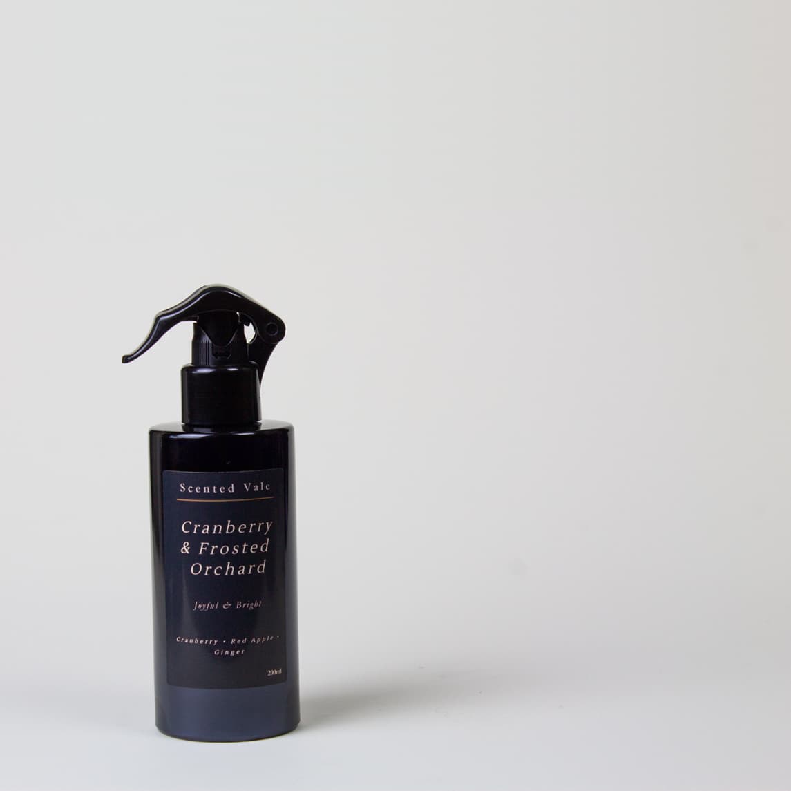 A dark violet pump bottle with a black sprayer, labelled 'Scented Valt Cranberry & Frosted Orchard', set against a plain light grey background.