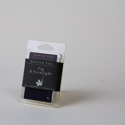 Scented Vale Fig & Fernlight wax melt package in a clear plastic clamshell and deep green label, photographed on a light grey background.