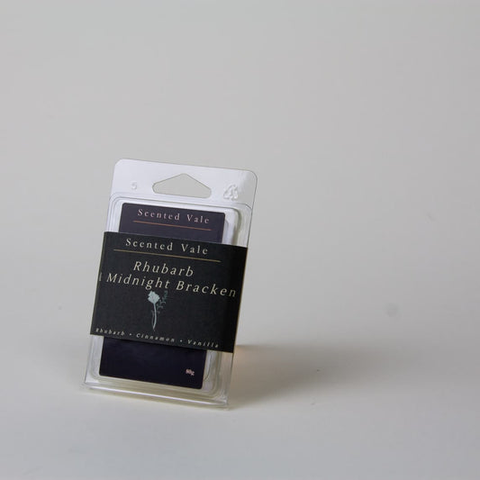 Scented Vale Rhubarb Midnight Bracken wax melts in a clear plastic clamshell package with a dark paper band label, photographed on a plain light grey background.